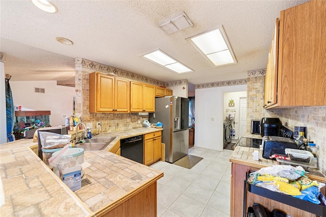 kitchen with kitchen peninsula, stainless steel fridge, sink, dishwasher, and tile counters