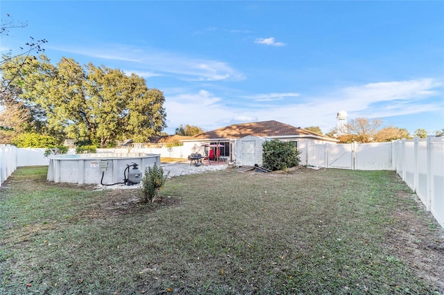 view of yard featuring a fenced in pool and a shed