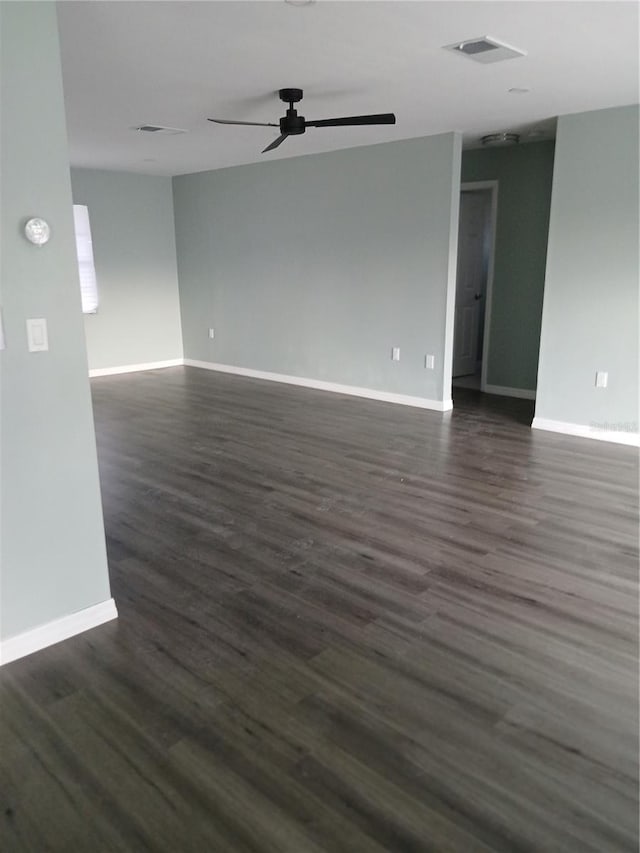 empty room with dark hardwood / wood-style floors and ceiling fan