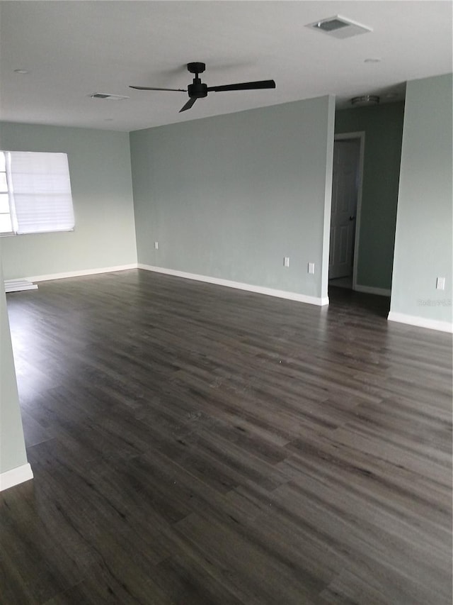 unfurnished room with ceiling fan and dark wood-type flooring