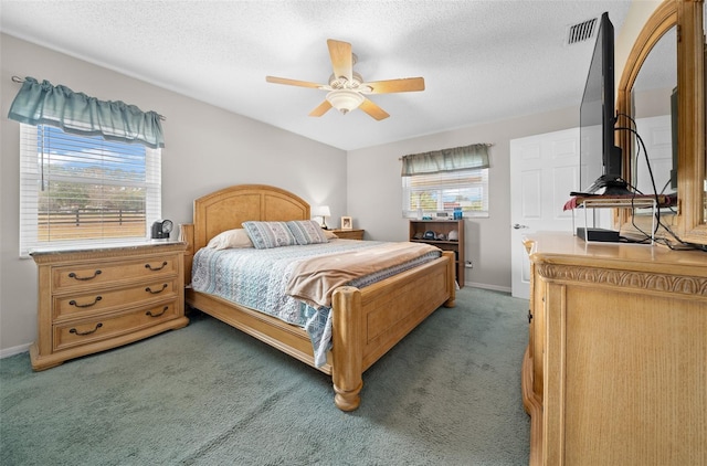 bedroom featuring ceiling fan, dark carpet, and a textured ceiling