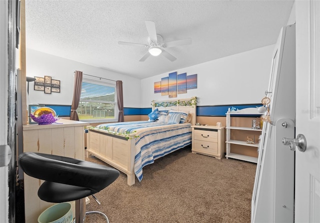 bedroom with a textured ceiling, dark carpet, and ceiling fan