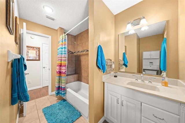 bathroom featuring tile patterned flooring, a textured ceiling, vanity, and shower / bath combo with shower curtain