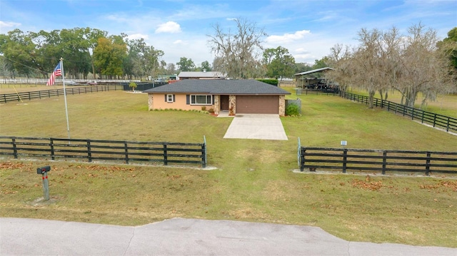 view of front of house with a garage, a rural view, and a front lawn