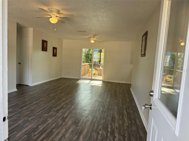 spare room with a textured ceiling, ceiling fan, and dark wood-type flooring