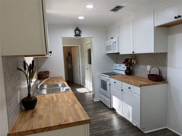 kitchen with white appliances, white cabinets, sink, a textured ceiling, and butcher block counters