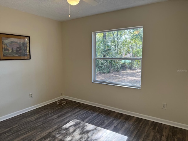 spare room with a textured ceiling, dark hardwood / wood-style flooring, and ceiling fan