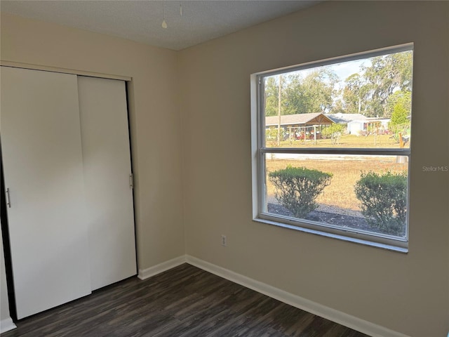 unfurnished bedroom featuring dark hardwood / wood-style flooring and a closet