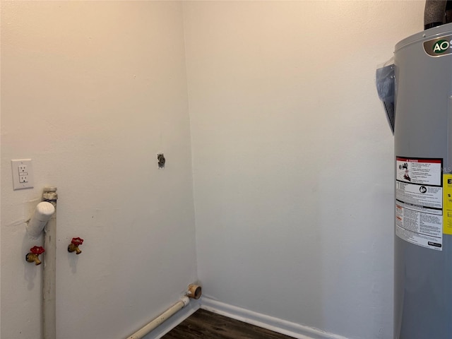 laundry room featuring electric dryer hookup, electric water heater, and dark wood-type flooring