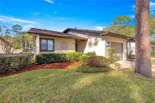 view of front of property featuring a garage and a front lawn