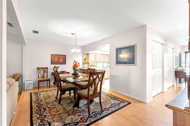 dining space featuring a notable chandelier and light hardwood / wood-style floors