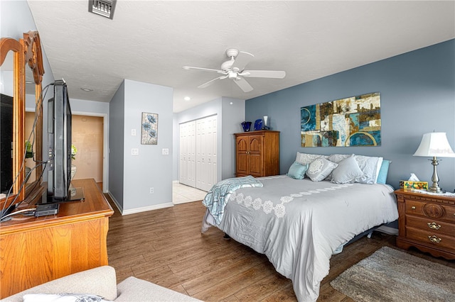 bedroom with ceiling fan, a closet, and hardwood / wood-style floors