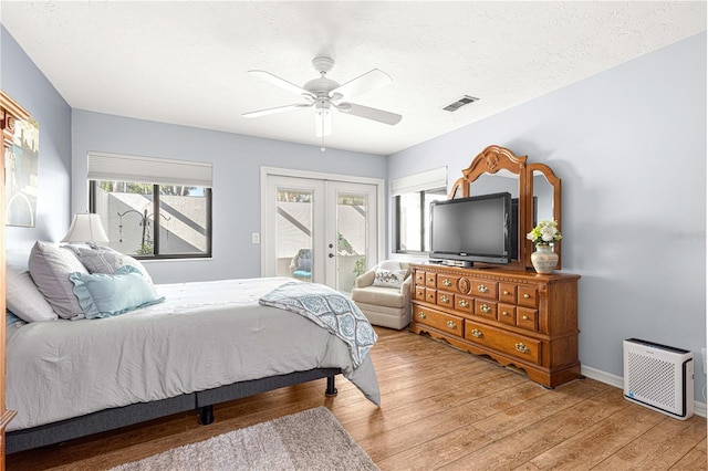 bedroom with access to exterior, ceiling fan, french doors, a textured ceiling, and hardwood / wood-style flooring