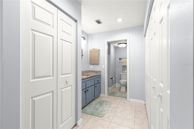 bathroom featuring toilet, vanity, and tile patterned floors