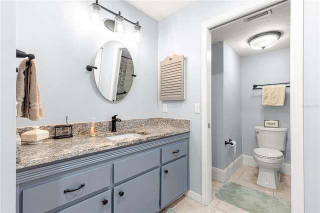 bathroom featuring toilet, vanity, and tile patterned floors