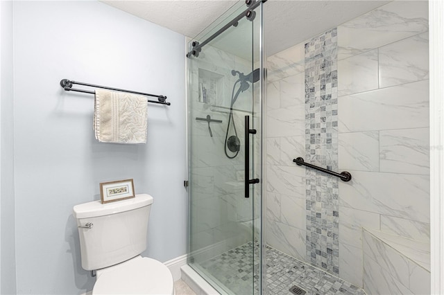 bathroom with an enclosed shower, toilet, and a textured ceiling