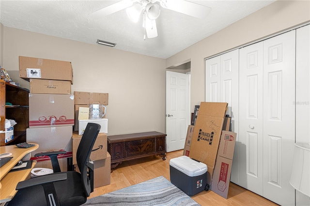 office area with ceiling fan, light hardwood / wood-style floors, and a textured ceiling