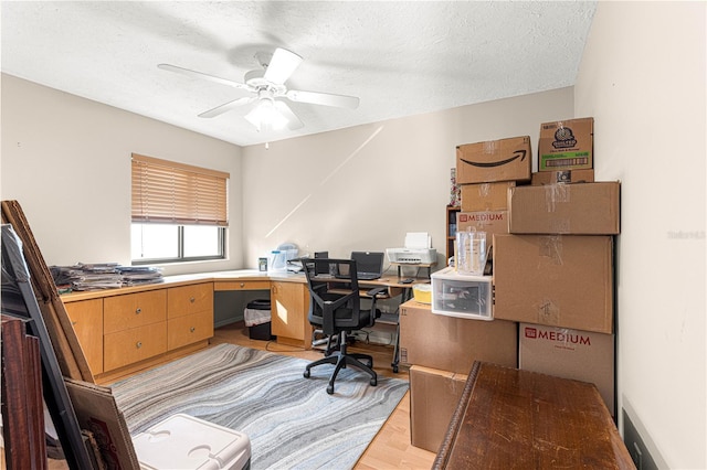 office featuring light wood-type flooring, a textured ceiling, and ceiling fan