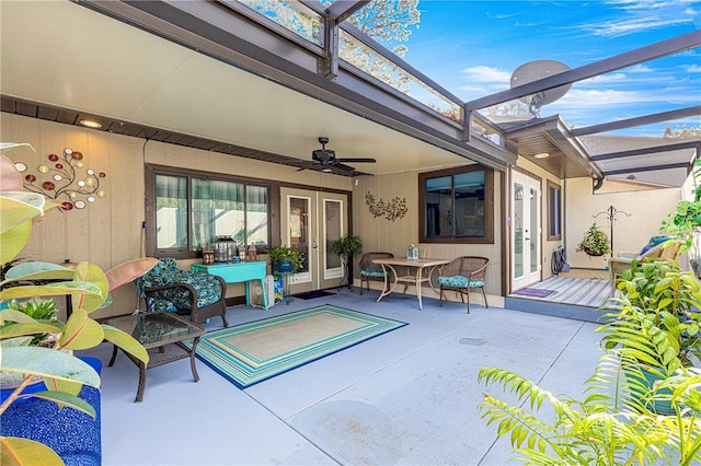 view of patio with ceiling fan and glass enclosure