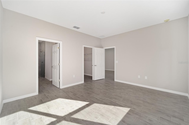 unfurnished bedroom with a spacious closet and a closet