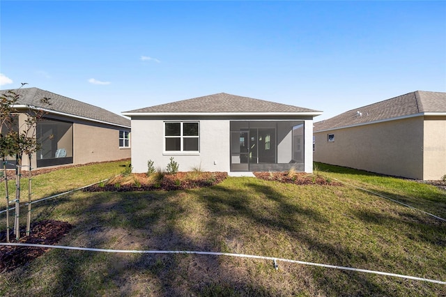 rear view of house featuring a sunroom and a yard