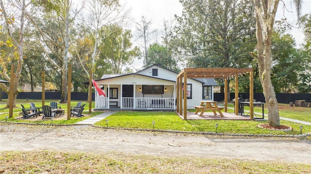 bungalow-style house featuring a pergola, a front yard, a fire pit, a patio area, and covered porch