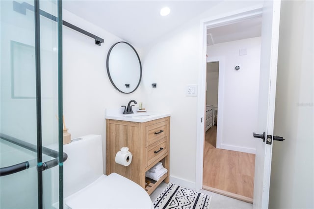 bathroom featuring an enclosed shower, vanity, and toilet