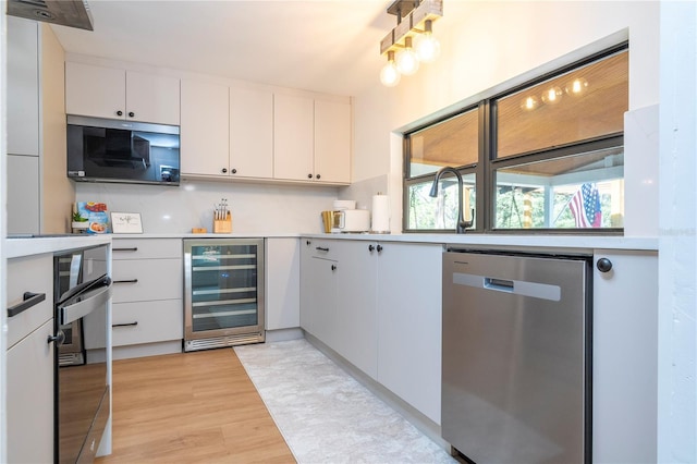 kitchen featuring white cabinets, stainless steel appliances, wine cooler, and tasteful backsplash