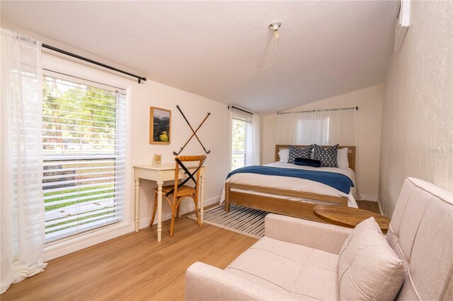 bedroom featuring vaulted ceiling and light wood-type flooring