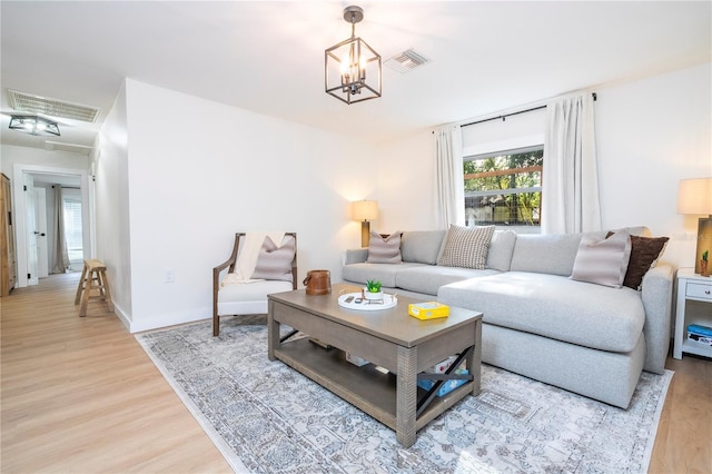 living room with hardwood / wood-style flooring and an inviting chandelier