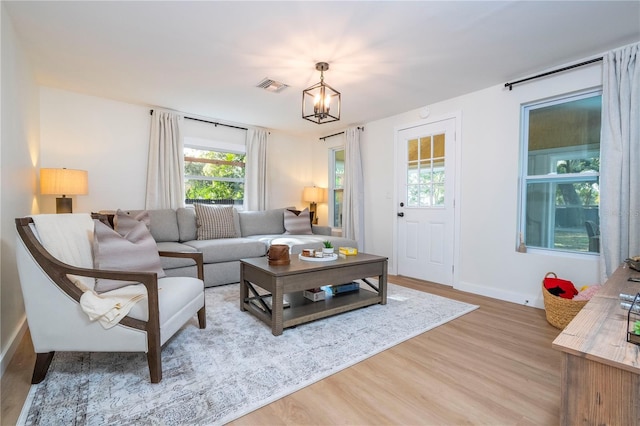 living room with light hardwood / wood-style flooring and a chandelier