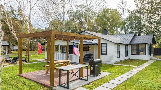 back of property featuring a yard, a pergola, and a patio area