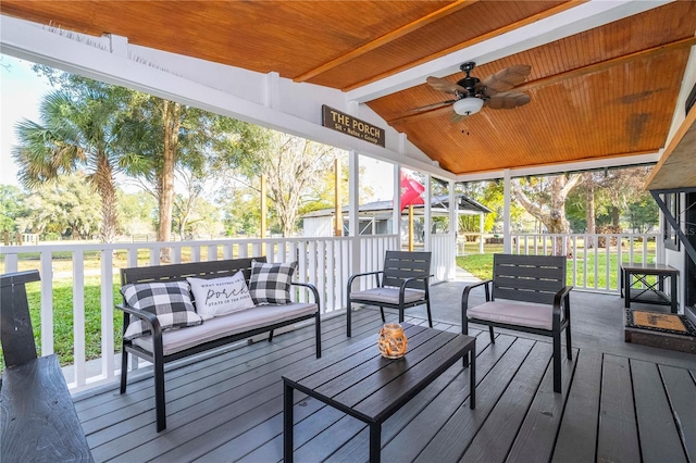 wooden deck with a lawn, outdoor lounge area, and ceiling fan