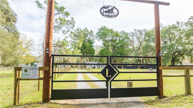 view of gate with a lawn