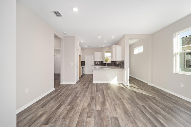 unfurnished living room featuring hardwood / wood-style flooring and a wealth of natural light