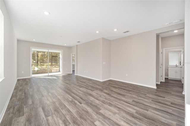 unfurnished living room with hardwood / wood-style flooring and sink