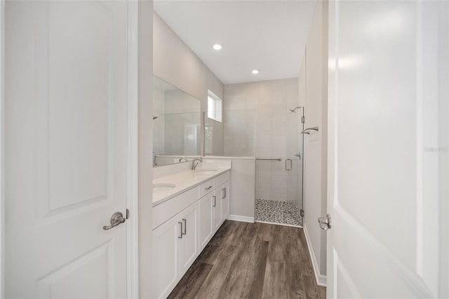 bathroom featuring hardwood / wood-style floors, vanity, and a shower with door