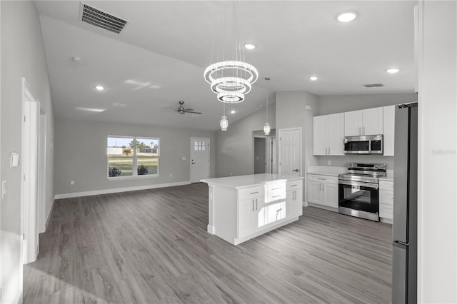 kitchen with a kitchen island, decorative light fixtures, light hardwood / wood-style floors, white cabinetry, and stainless steel appliances