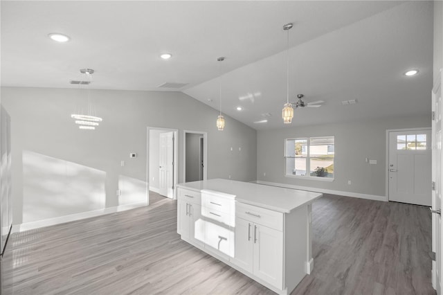 kitchen with light hardwood / wood-style floors, white cabinetry, hanging light fixtures, and ceiling fan