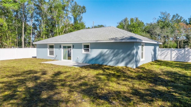 back of property with a yard and a patio area