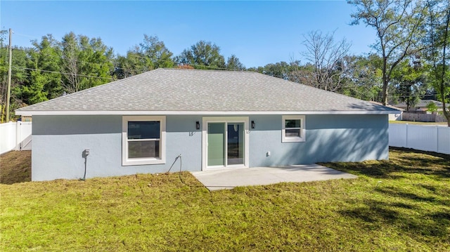 rear view of property with a lawn and a patio