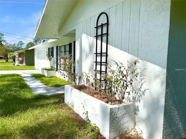 view of property exterior with a garage and a lawn