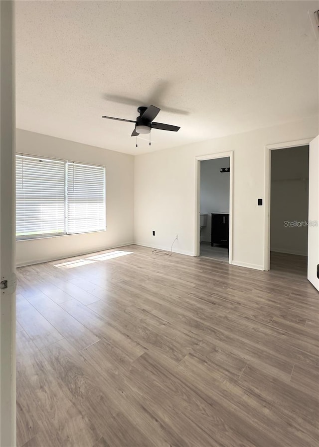 spare room with wood-type flooring, ceiling fan, and a textured ceiling