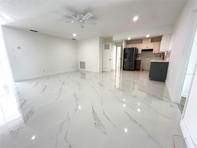 interior space with ceiling fan and sink