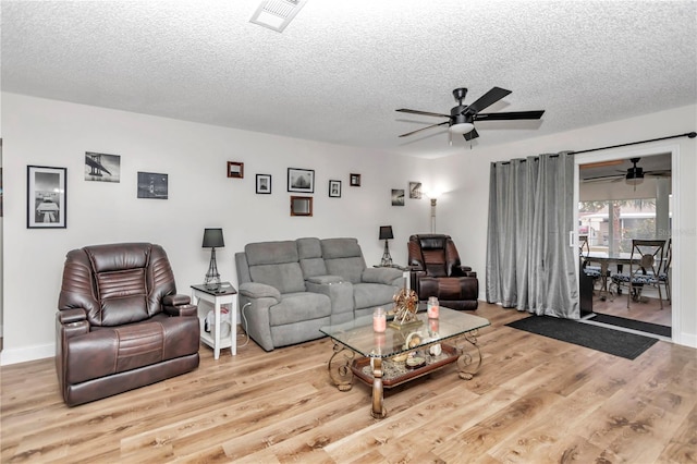 living room with a textured ceiling, ceiling fan, and light hardwood / wood-style flooring