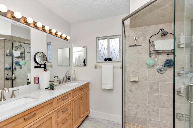 bathroom with a textured ceiling, an enclosed shower, and vanity