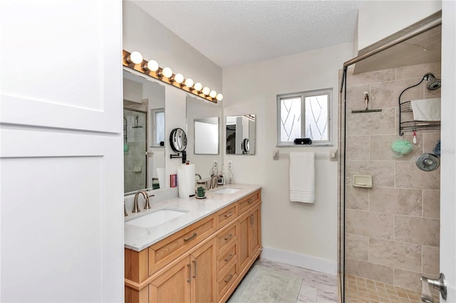 bathroom featuring walk in shower, vanity, and a textured ceiling