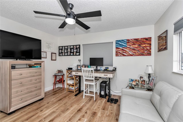 home office with ceiling fan, a textured ceiling, and light hardwood / wood-style flooring