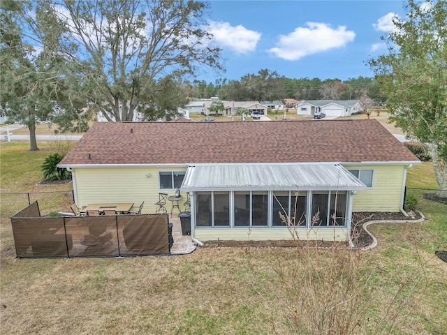 back of property featuring a sunroom and a lawn