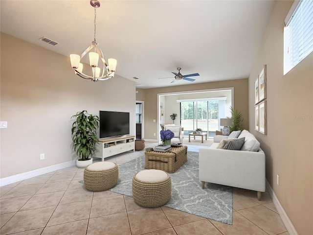 living room with ceiling fan with notable chandelier and light tile patterned floors